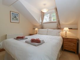 A bedroom with a bed and two lamps at Wren Cottage in Ross-on-Wye