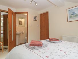 A bedroom with a bed and attached bathroom at Wren Cottage in Ross-on-Wye