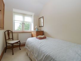 A bedroom with a bed and a chair at Wren Cottage in Ross-on-Wye