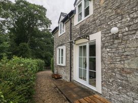 An outdoor view of a stone cottage with a gravel pathway at Wren Cottage in Ross-on-Wye