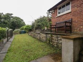 A garden with a bench and stone wall at Wren Cottage in Ross-on-Wye