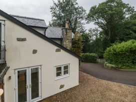 An exterior view of a house with a driveway and garden at Wren Cottage in Ross-on-Wye