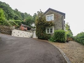 A house with a driveway surrounded by greenery at Wren Cottage in Ross-on-Wye