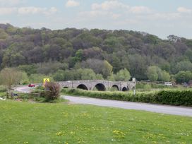 A bridge over a road with trees and grass at Wren Cottage in Ross-on-Wye