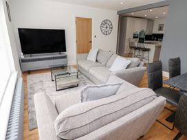 A living room with a television and sofa at Rose Cottage in Dunstan near Embleton
