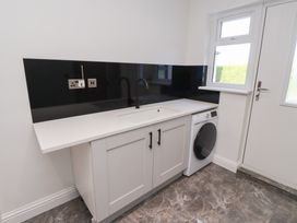 A laundry room with a sink and washing machine at Rose Cottage in Dunstan near Embleton