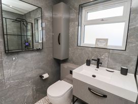 A bathroom with a shower and washbasin at Rose Cottage, Dunstan near Embleton