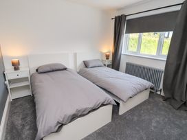A bedroom with twin beds and bedside table at Rose Cottage Dunstan near Embleton