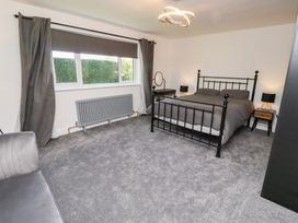 A bedroom with a bed and nightstands at Rose Cottage Dunstan near Embleton