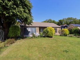 A garden with a house and trees at Rose Cottage in Dunstan near Embleton