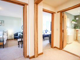 A hallway with doors leading to two bedrooms and a bathroom at Church Thatch in Abbotskerswell