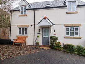 An outdoor view of a house with a bench and plants at Poldam in St Austell