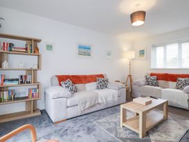 A living room with a bookshelf and sofas at Poldam St Austell