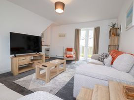 A living room with a television and furniture at Poldam St Austell