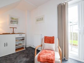 A sitting area with a chair and shelf at Poldam in St Austell