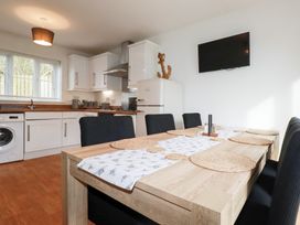 A kitchen with a dining table and chairs at Poldam St Austell