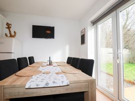 A dining room with a table and chairs at Poldam in St Austell