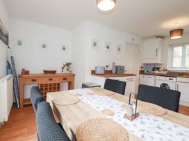 A kitchen with a dining table and chairs at Poldam in St Austell