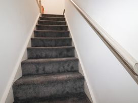 A staircase with carpeted steps and a handrail at Poldam St Austell
