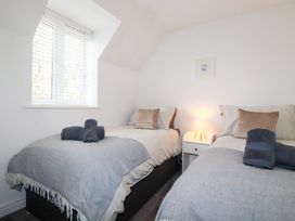 A bedroom with two beds and a lamp at Poldam in St Austell