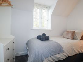 A bedroom with a bed and dresser at Poldam St Austell