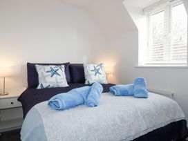 A bedroom with a bed and towels at Poldam, St Austell