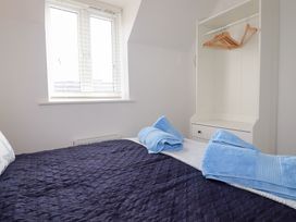 A bedroom with a bed and wardrobe at Poldam in St Austell