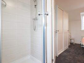 A bathroom with a shower and wardrobe at Poldam in St Austell