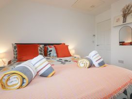 A bedroom with a bed and towels at Poldam in St Austell