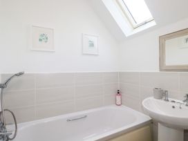 A bathroom with a bathtub and sink at Poldam St Austell
