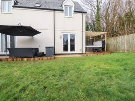 A backyard with a hot tub and outdoor furniture at Poldam in St Austell