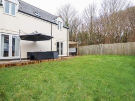 A house with a garden and patio furniture at Poldam in St Austell