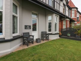 An entrance area with two chairs beside a door at Ty Llwyd in Llandudno