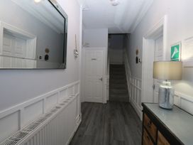 A hallway with a mirror and stairs at Ty Llwyd in Llandudno