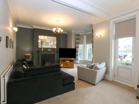 A living room with a sofa and television at Ty Llwyd in Llandudno