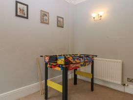 A game room with a foosball table and wall art at Ty Llwyd in Llandudno