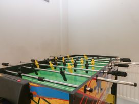 A foosball table with yellow and black players in a game room at Ty Llwyd, Llandudno