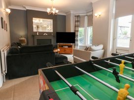 A living room with a foosball table and furniture at Ty Llwyd in Llandudno