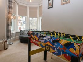A game room with a foosball table and an armchair at Ty Llwyd in Llandudno