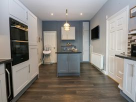 A kitchen with an island and oven at Ty Llwyd in Llandudno