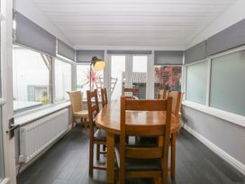 A dining room with a round table and chairs at Ty Llwyd in Llandudno