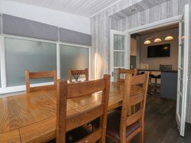 A dining room with a wooden table and chairs at Ty Llwyd in Llandudno