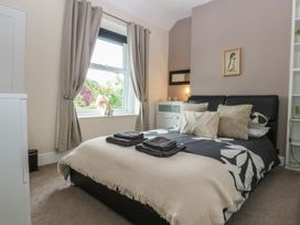 A bedroom with a bed and window at Ty Llwyd in Llandudno