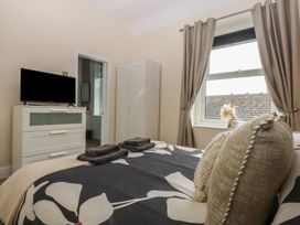A bedroom featuring a bed with pillows and a television at Ty Llwyd in Llandudno