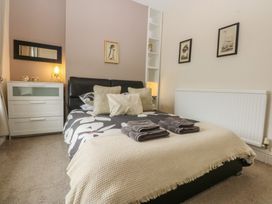 A bedroom with a bed and dresser at Ty Llwyd in Llandudno
