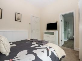 A bedroom with a bed and a television at Ty Llwyd in Llandudno