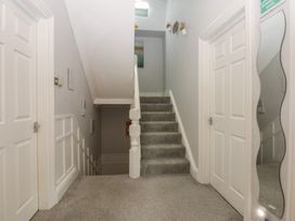 A hallway with stairs and doors at Ty Llwyd in Llandudno