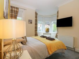 A bedroom with a bed and lamp at Ty Llwyd in Llandudno