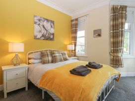 A bedroom with a bed and nightstand at Ty Llwyd in Llandudno