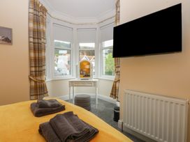 A bedroom with a bed and television at Ty Llwyd in Llandudno